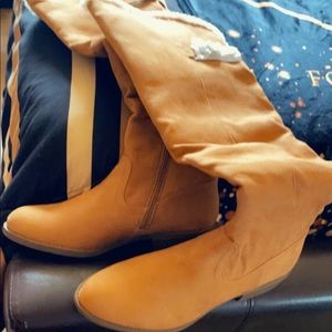 Tan colored tall knee boots with fur lining